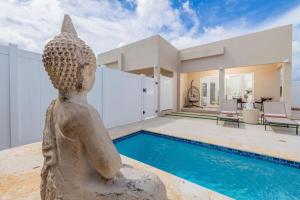 a home with a pool and a statue in the yard at Dreamy Getaway w/ Private Pool | BBQ |5min Airport in Tanki Lender