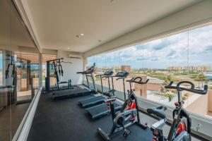 a gym with several tread machines and a large window at AtMonchi Stylish Condo in Palm-Eagle Beach