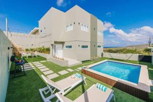 a villa with a swimming pool on a lawn at KoeriBoeri 7F in Babijn