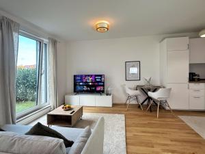 a living room with a couch and a table at HolidayHome Apartments I Airport Deluxe Condo with Terrace in Schönefeld