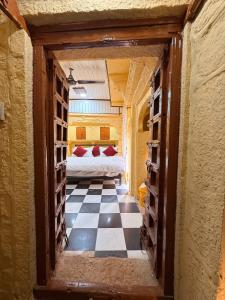 Habitación con cama y suelo de tablero de ajedrez en Hotel Temple View, en Jaisalmer