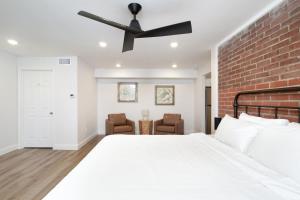 una camera da letto con un letto bianco e un muro di mattoni di Cedars Peak Downtown 2 Condos a Sevierville