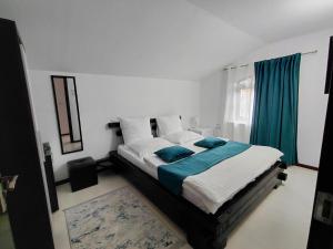 a bedroom with a bed with blue and white pillows at Casa Nico Nelu Duplex in Arieşeni