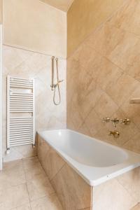 a white bath tub in a bathroom with tiles at XIIGiugno Boutique in Bologna +22 photos