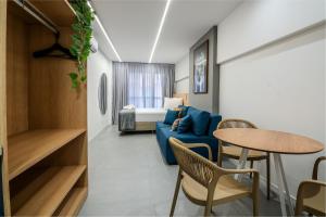 un salon avec un canapé bleu et une table dans l'établissement Luggo Mauá - Rio de Janeiro, à Rio de Janeiro