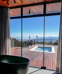 a view from the living room of a house with a large window at Vista espetacular, piscina e banheira no quarto! in Maria da Fé +27 photos