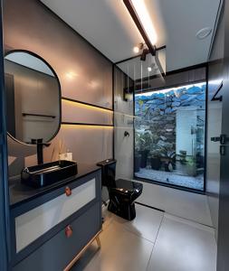 a bathroom with a sink and a mirror at Vista espetacular, piscina e banheira no quarto! in Maria da Fé