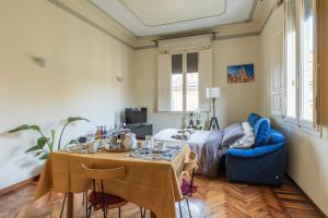 a living room with a table and a blue chair at XIIGiugno Boutique in Bologna