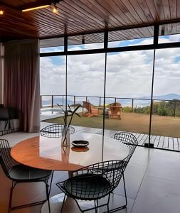 a dining room with a table and chairs and a balcony at Vista espetacular, piscina e banheira no quarto! in Maria da Fé