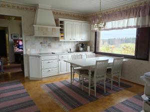 a kitchen with a table and chairs and a window at Villa Tolonen in Talosenkylä