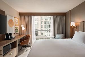 a hotel room with a bed and a desk and a window at Holiday Inn & Suites Vancouver Downtown by IHG in Vancouver +79 photos