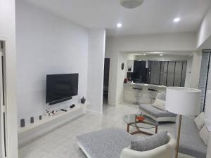 Una sala de estar con un televisor en una pared blanca. en Paknampran 2 Bedrooms Pool Villa, en Pran Buri
