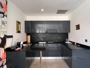 une cuisine avec des armoires noires et un comptoir noir dans l'établissement Villa Fiori Luxury Italian Villa, Pool & Spa, Marrakech, à Douar bel Rhanodour