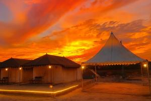 two tents with a sunset in the background at Stayguru Patgar Tent in Dhordo +8 photos