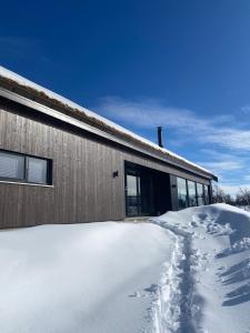 a snow covered yard next to a building at Spacious modern family chalet in Solhovda close to hiking, skiing & nature in Hol