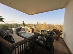 un balcon avec des chaises et une table et une vue dans l'établissement Villa Fiori Luxury Italian Villa, Pool & Spa, Marrakech, à Douar bel Rhanodour