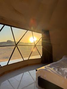 une chambre avec un lit et une vue sur l'océan dans l'établissement Wadi Rum CAMP, à Disah