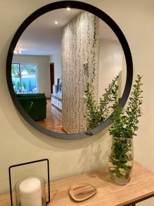 a mirror on a wall with a vase on a table at Spacious, cozy apartment with garden in Logroño