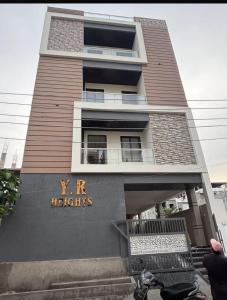 a tall building with a sign that reads xr heights at YR Heights Home Stay in Hyderabad