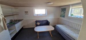 a small kitchen with a bench and a table and a chair at Fihermans House Joanna in Hirtshals