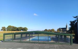 a glass pavilion with a pool in a park at Le Bonheur En Bretagne in Rouillac