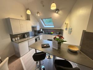 a small kitchen with a table and some chairs at The Sawmills, Carlisle - Spacious 4 Bedroom Family House - Free WiFi - & Parking - Walk to Carlisle Castle in Carlisle