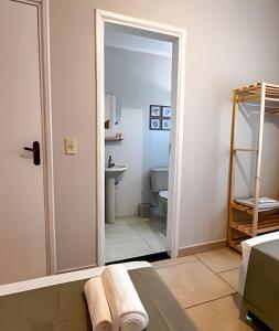ein Badezimmer mit einer Tür, die zu einer Toilette führt in der Unterkunft Ap 101 - Apartamento no centro da cidade in Maria da Fé + 27 Fotos