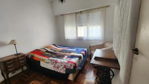a bedroom with a bed and a table and a window at Muy Buen Departamento con vista al Mar desde el Balcon Dos Dormitorios a dos Cuadras del Mar sobre Avenida Colon in Mar del Plata