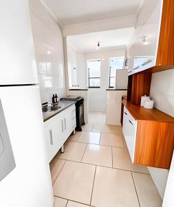 a kitchen with white cabinets and white tile floors at Ap 101 - Apartamento no centro da cidade in Maria da Fé +27 photos