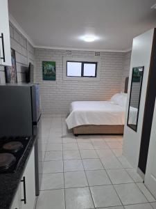 イースト・ロンドンにあるGrace Villas 31のベッドルーム1室(ベッド1台付)、キッチン(コンロ付)