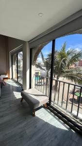 a room with a large window with a bench on a balcony at Hotel Plaza El Santuario in Santuario