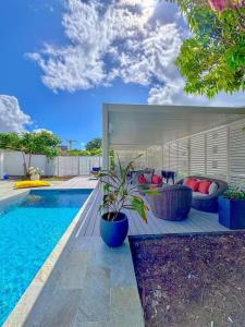 a house with a swimming pool with a couch at Villa élégante avec piscine à Cluny Schoelcher in Schœlcher