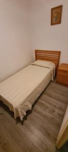 a bed in a bedroom with a wooden headboard at Antiga Fonda la Palma in Tremp