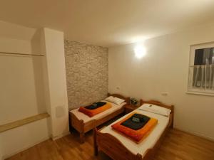 two beds in a small room with wooden floors at ZeitWinkelHaus - Apartments with garden in Bad Sooden-Allendorf