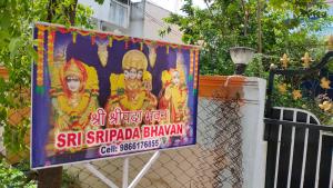 a sign on a fence with two women on it at Sree Sripadha Bhavan in Pithāpuram