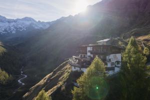 a building on the side of a hill with mountains at Hochfirst in Corvara in Passiria +27 photos