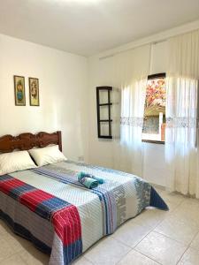a bedroom with a bed and a window at Cantinho do Céu - Miguel Pereira in Miguel Pereira