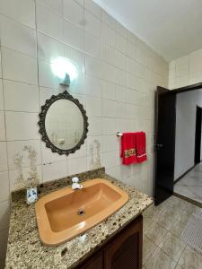 a bathroom with a sink and a mirror at Cantinho do Céu - Miguel Pereira in Miguel Pereira