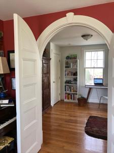 an archway leading into a living room with a piano at Oceanfront - Downtown in historic New England in Salem