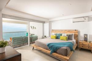 a bedroom with a bed with a view of the ocean at Luxury 2-Bedroom Beachfront Oasis – Two Balconies to Soak in the Views in Puerto Vallarta +41 photos