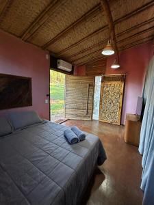 a bedroom with a bed with two blue towels on it at Hospedagem Pé de Serra in Botucatu