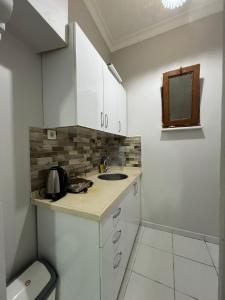a small kitchen with white cabinets and a sink at Sultanahmet Blue Suites in Istanbul