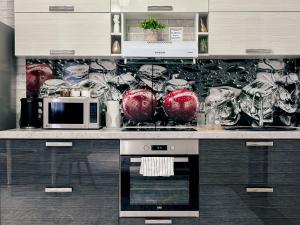 a kitchen with a counter with red vases on it at Евродвушка в ЖК Ирина in Pavlodar +14 photos