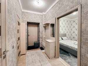 a small bedroom with a bed and a mirror at Евродвушка в ЖК Ирина in Pavlodar