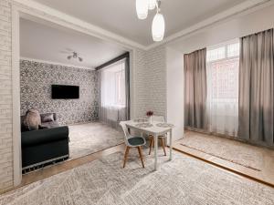 a living room with a table and a couch at Евродвушка в ЖК Ирина in Pavlodar