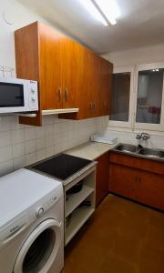 a kitchen with a washing machine and a microwave at Antiga Fonda la Palma in Tremp
