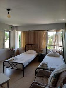 a bedroom with two beds and a couch at Family Room's Eirini in Mesolongion
