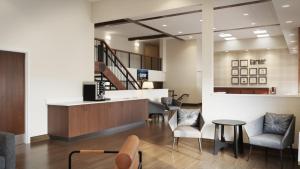 a lobby with chairs and a table and a staircase at Garner Hotel Butte Southeast by IHG in Butte