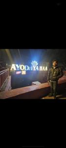 a man is standing in front of a sign at Rishabh guest house in Ayodhya