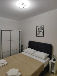 a bedroom with a large bed with a black headboard at Ismini's Luxury Villas in Mirodháton